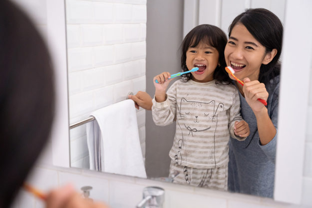 types of toothbrushes (1) mother and daughter trying different types of toothbrushes
